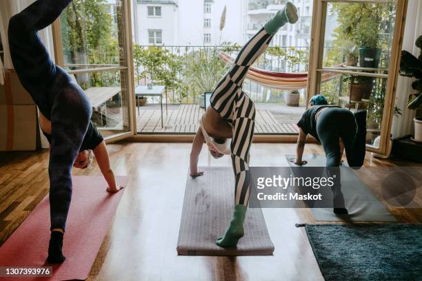 male and female friends doing stretching exercise at home - room mates male stock-fotos und bilder