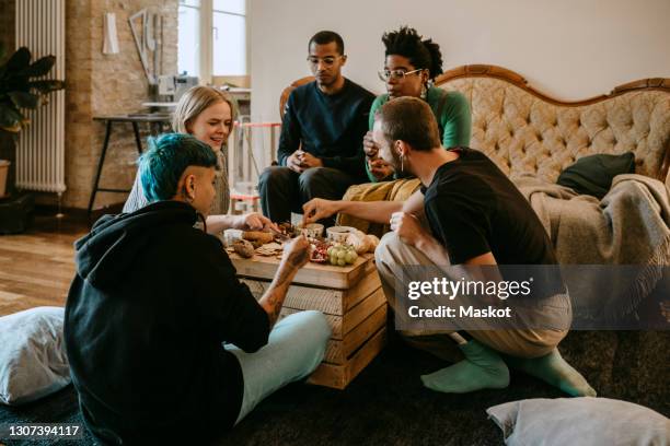 female and male friends having breakfast in living room at home - social gathering fotografías e imágenes de stock