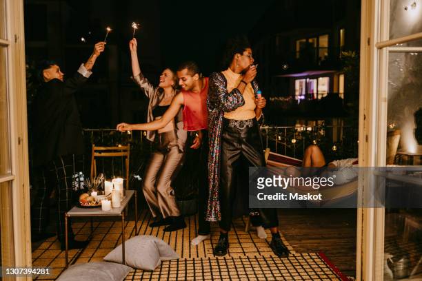 cheerful multi-ethnic friends dancing in back yard during party celebration - party stock pictures, royalty-free photos & images