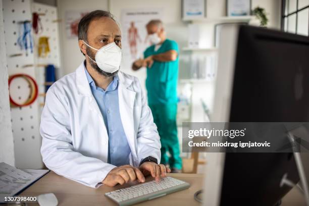 Computer Medical Mask Masked Doctor At Computer Photos and Premium High Res Pictures - Getty ...