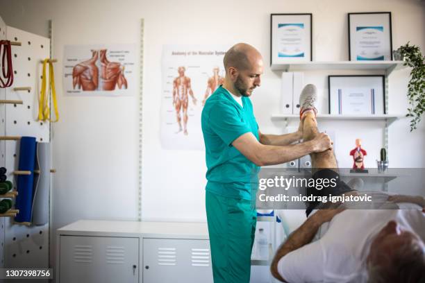 fisioterapista al lavoro per il recupero del paziente in amatorio medico - osteopata foto e immagini stock