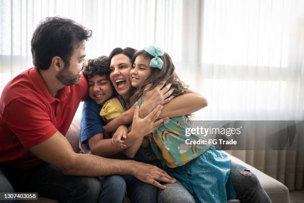 happy family embracing at home - latin american and hispanic ethnicity home stock pictures, royalty-free photos & images