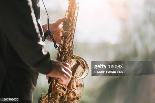 lifehack asian chinese mature man practicing saxophone at home during weekend leisure time - saxophone stock pictures, royalty-free photos & images