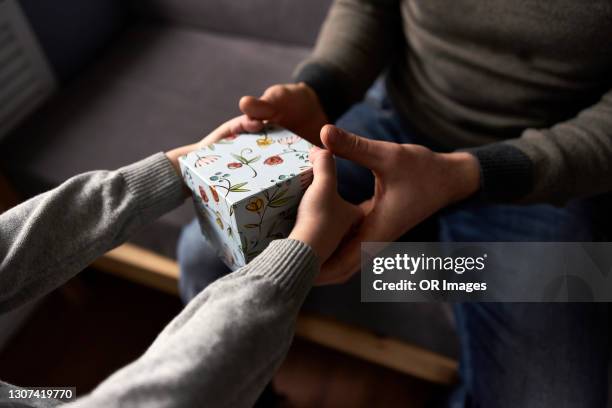 son handing over gift to his father - child giving gift stock-fotos und bilder