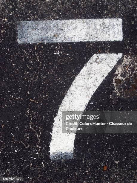 number seven painted white and weathered on asphalt in miami - zahl 7 stock-fotos und bilder