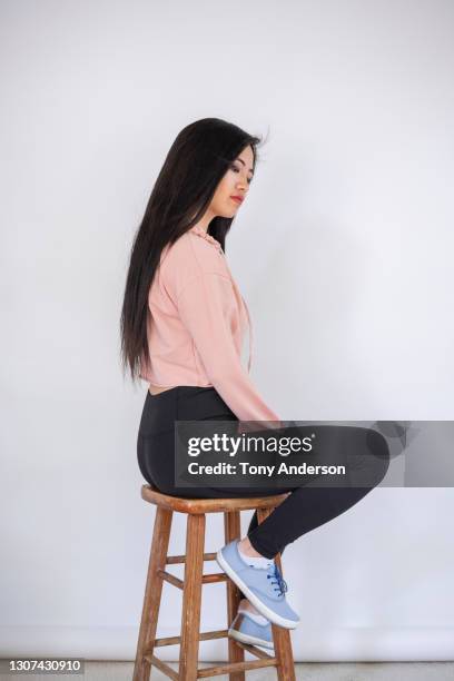 portrait of young asian woman - women sitting on stools stock pictures, royalty-free photos & images