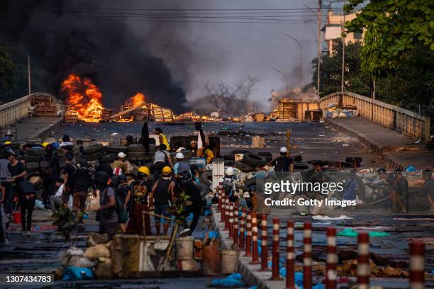Smoke rises from tires burning at a barricade erected by protesters to stop government forces crossing a bridge on March 16, 2021 in Yangon, Myanmar....