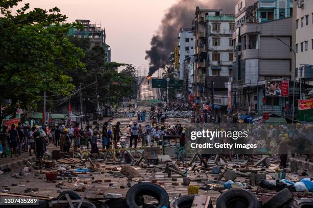 Smoke rises from tires burning at barricades erected by protesters after military junta forces attempted to breach them on March 16, 2021 in Yangon,...