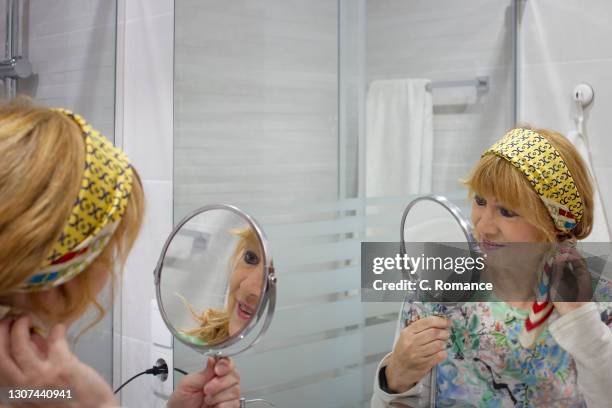woman looking in the mirror - espejo de mano fotografías e im
