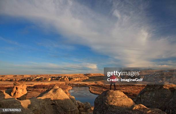 man admiring incredible view at writing-on-stone provincial park in alberta canada - alberta badlands stock pictures, royalty-free photos & images