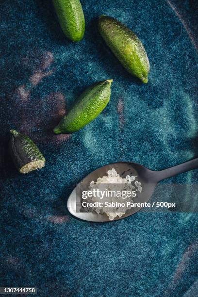 directly above shot of finger lime pulp in spoon on table - finger lime stock pictures, royalty-free photos & images