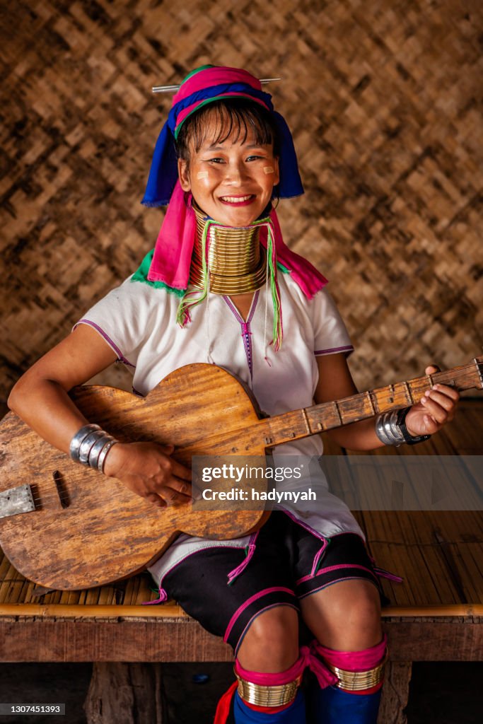 Ung kvinna från Long Neck Karen-stammen som spelar gitarr, norra Thailand