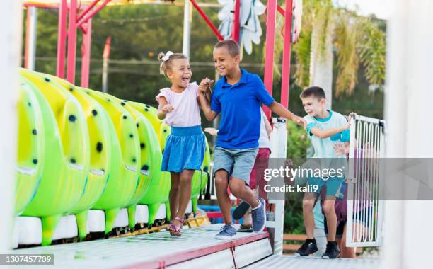 enfants obtenant sur le tour au parc d’attractions - famille montagnes russes photos et images de collection