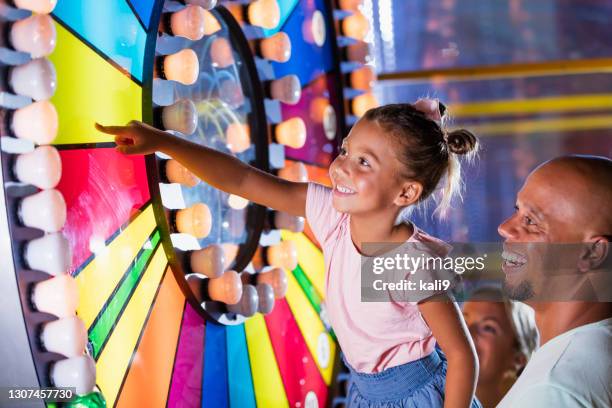 mixed race girl with father at amusement arcade - arcade stock pictures, royalty-free photos & images