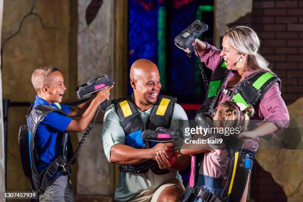 interracial family with two children playing laser tag - playing tag stock pictures, royalty-free photos & images