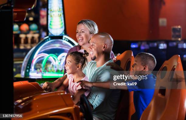 mixed race family playing game at video arcade - arcade stock pictures, royalty-free photos & images