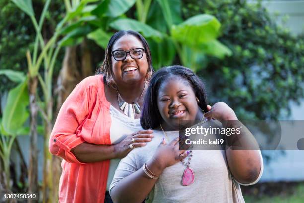 ダウンを持つアフリカ系アメリカ人の祖母と十代の女の子 - chubby teenager ストックフォトと画像