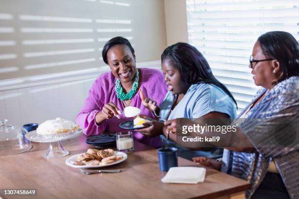 drie generaties, meisje met neer, het eten van dessert - american pie stockfoto's en -beelden