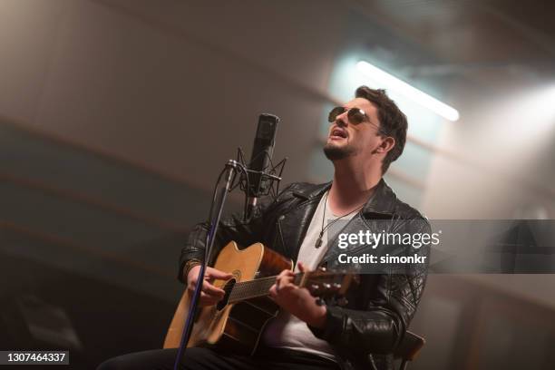 cantante masculino tocando la guitarra - white male singers fotografías e imágenes de stock
