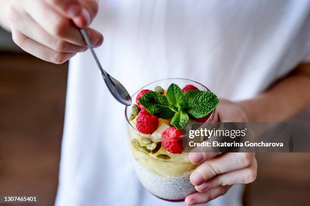 close-up of a girl in a casual
clothing with chia seed pudding with berries and fruit. - smoothie close up textfreiraum stock-fotos und bilder