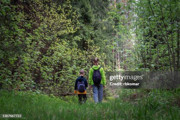 lonely sad children - sibling with backpacks got lost in a spooky dark woodland - lost stock pictures, royalty-free photos & images