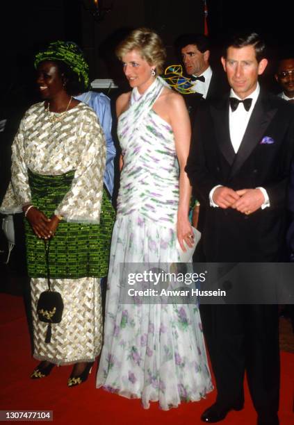 Prince Charles, Prince of Wales and Diana, Princess of Wales, wearing a chiffon halterneck evening gown designed by Catherine Walker, stand next to...