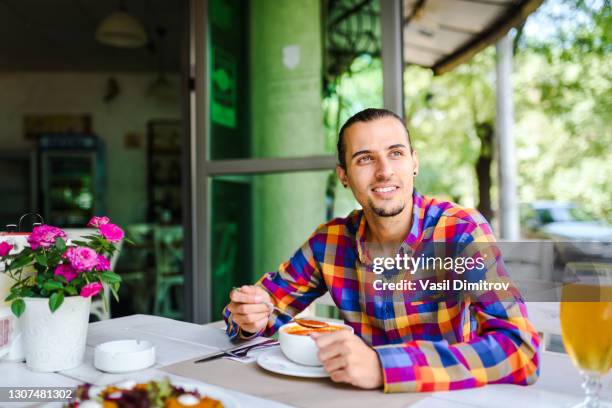 young man eating in a restaurant. - eating soup stock pictures, royalty-free photos & images