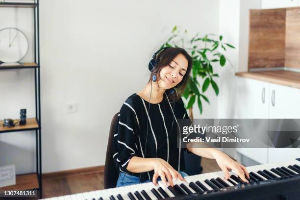 man playing the piano stock photo.  creating / recording music at home concept. - electric piano stock pictures, royalty-free photos & images