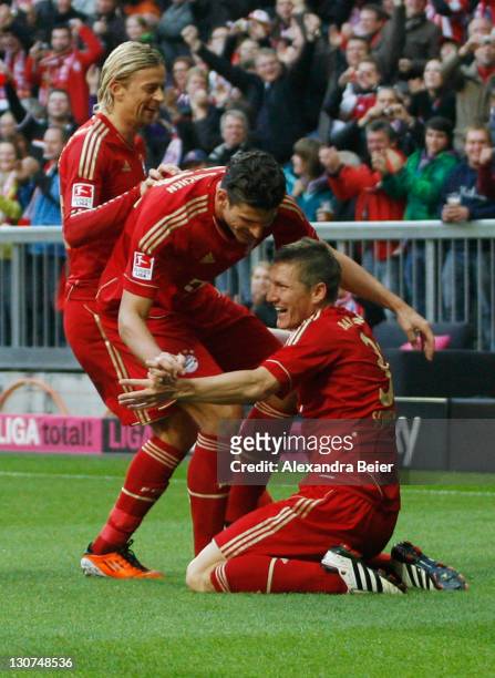 Bastian Schweinsteiger of Bayern Muenchen celebrates his first goal together with teammates Mario Gomez and Anatoliy Tymoshchuk during the Bundesliga...