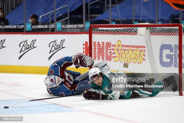 Derek Grant of the Anaheim Ducks ends up in the net with goalie Hunter Miska of the Colorado Avalanche after being fouled from behind in the first...