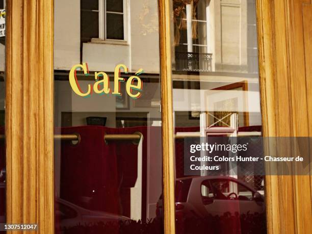 close-up of the window of a retro-styled parisian cafe - french cafe stock-fotos und bilder