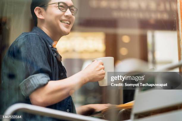 smart confidence asian startup entrepreneur business owner businessman smile hand hold coffee cup woking in cafe background - smile asia woman stock-fotos und bilder