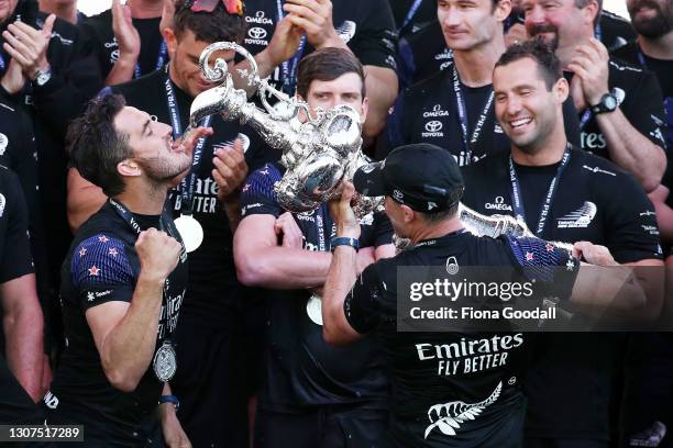 Emirates Team New Zealand's Blair Tuke drinks champagne out of the "Auld Mug" trophy during the podium presentation after winning race and the...