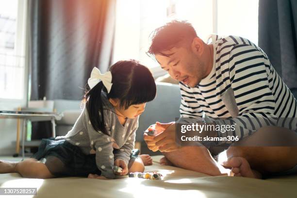 quality time of family south east asian family father teaching cute daughter play toys at home together - east asian ethnicity fotografías e imágenes de stock