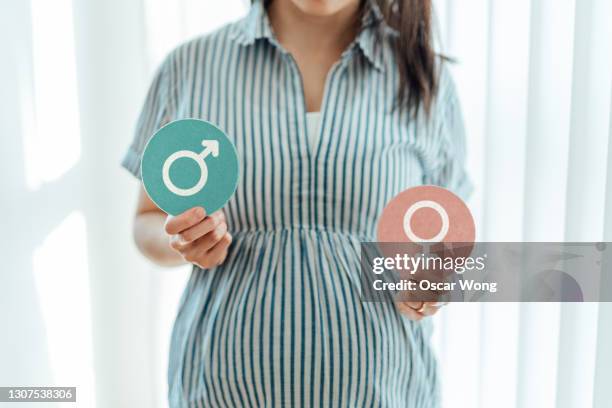 pregnant woman predicting the sex of her baby - gender symbol stock pictures, royalty-free photos & images