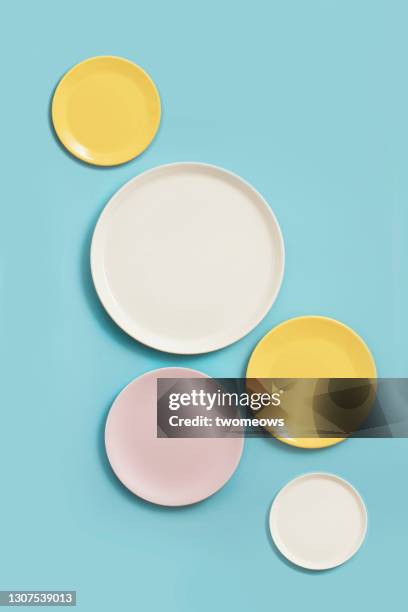 overhead view empty various coloured plates on blue colour background. - flat lay photos et images de collection