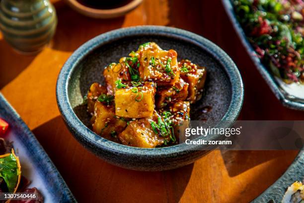 tofu cubes fried and served with black and white sesame in a bowl - tofu stock pictures, royalty-free photos & images
