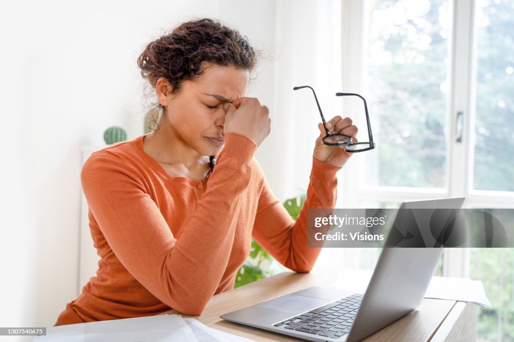 Woman feeling tired and overworked working from home