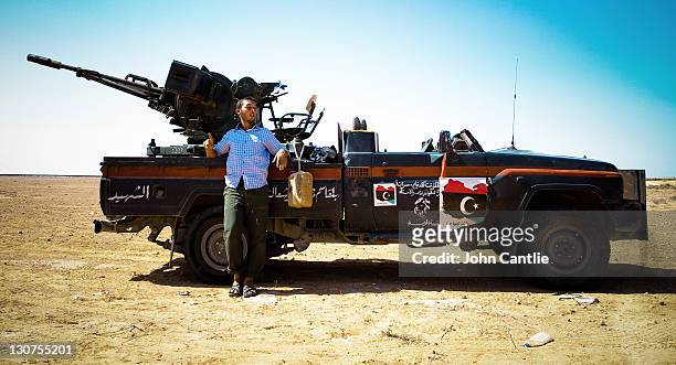 An NTC fighter stands next to his cut-off Toyota Land Cruiser with 14.5mm heavy machine-gun conversion on September 6, 2011 in Misrata, Libya....