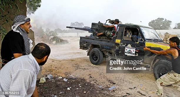 Gun truck manned NTC forces and armed with a 23mm anti-aircraft gun fires at loyalist positions on October 11, 2011 in Sirte, Libya. Fighting in...