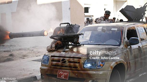 An NTC fighter sits in his Grand Hiland pick-up truck as a launch pad for a Milan anti-tank rocket on October 10, 2011 in Sirte, Libya. Fighting in...