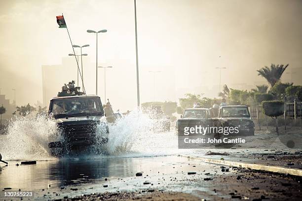 Heavily-armed gun trucks manufactured in Misrata plows through deep water during the final days of the battle of Sirte on October 12, 2011 in Sirte,...