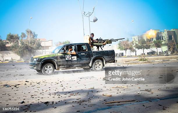 Chinese-made Grand Hiland pick-up truck reverses towards loyalist positions while the gunner lays down heavy fire on October 12, 2011 in Sirte,...
