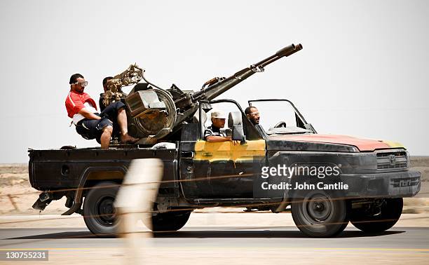Fighters advance to the frontline in a Toyota painted in the distinctive black, yellow and red colours on September 4, 2011 in Misrata, Libya....