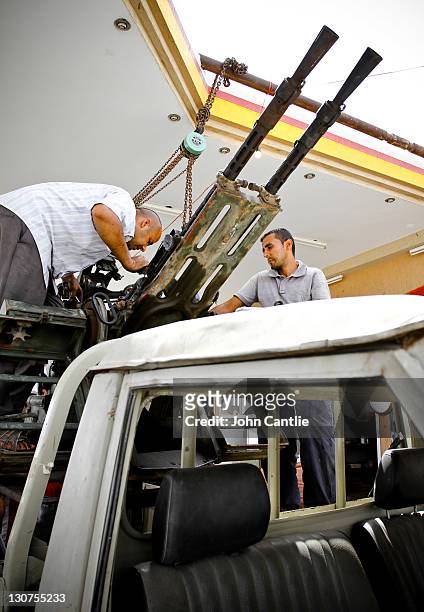 Mechanics fit a new 23mm anti-aircraft gun to the bed of a Toyota Land Cruiser on September 4, 2011 in Misrata, Libya. Fighting in Libya has ceased...