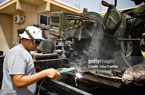 Mechanics welds a baseplate onto an anti-aircraft gun fitted to the bed of a Toyota Hilux on September 4, 2011 in Misrata, Libya. Fighting in Libya...