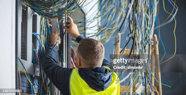 elektriker arbeitet auf der baustelle - elektrisch stock-fotos und bilder
