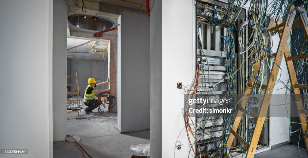 Elektricien die bij bouwwerf werkt