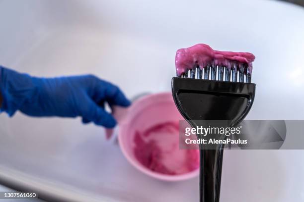 mixing pink vibrant hair color - brush in woman's hair imagens e fotografias de stock