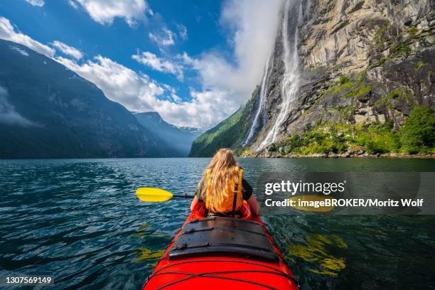 young woman paddling in a kayak, geirangerfjord, near geiranger, norway - geiranger stock pictures, royalty-free photos & images